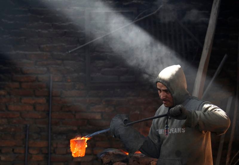 © Reuters. A worker carries a crucible of melted copper as he makes statues at a workshop in Lalitpur, Nepal December 23, 2015. REUTERS/Navesh Chitrakar/File Photo