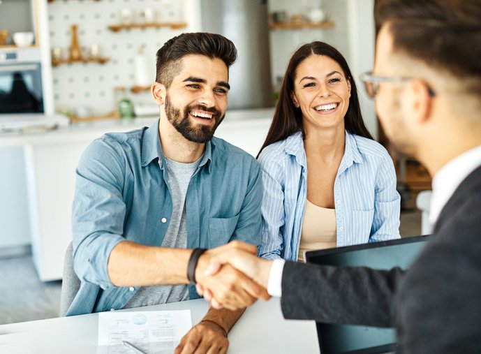 A couple discusses alternative investment management with their advisor.