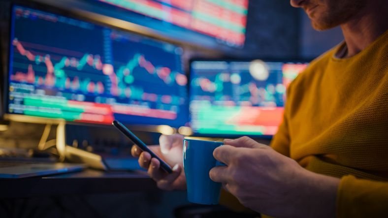 A hedge fund analyst takes a break from studying price charts while working late one night.