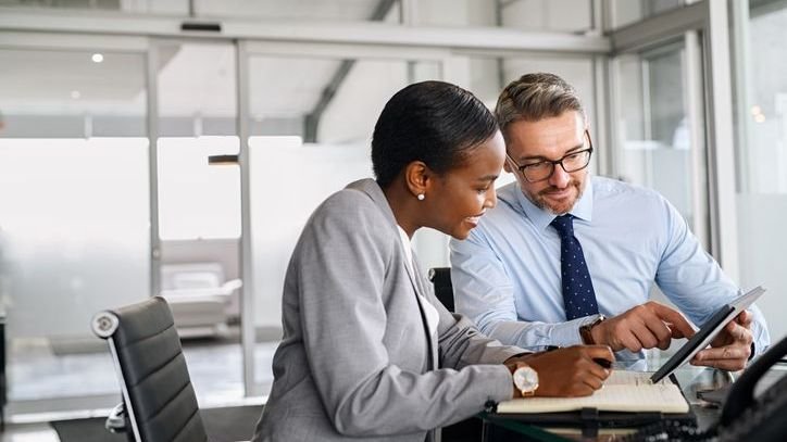 A pair of investment analysts discuss leveraged loan indexes during a meeting.