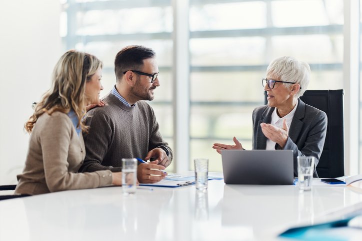 A couple discusses investment risk management strategies with their financial advisor.